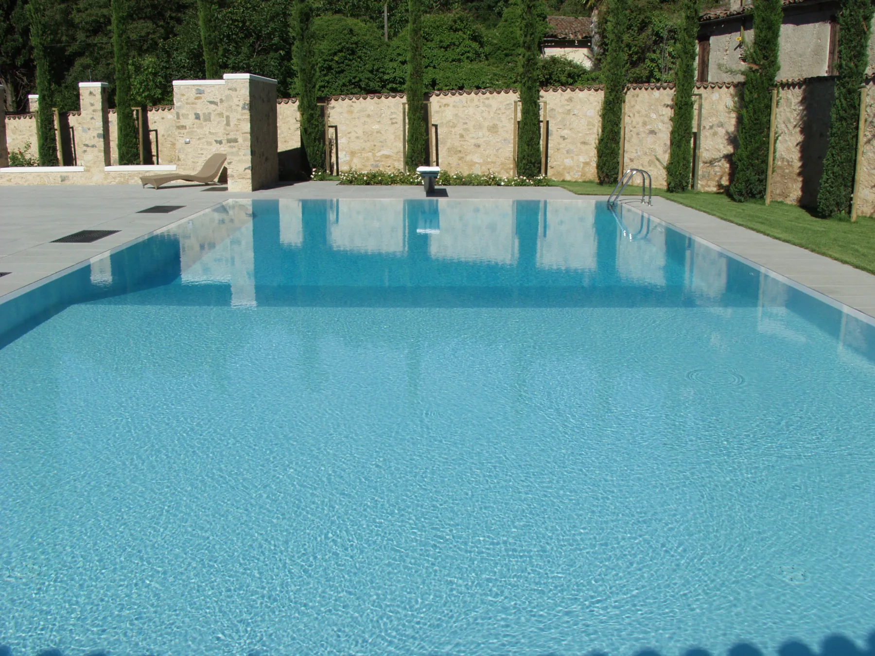 piscina a sfioro con pavimentazione